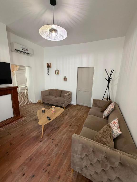 a living room with a couch and a table at Maison des Capucins in Nérac
