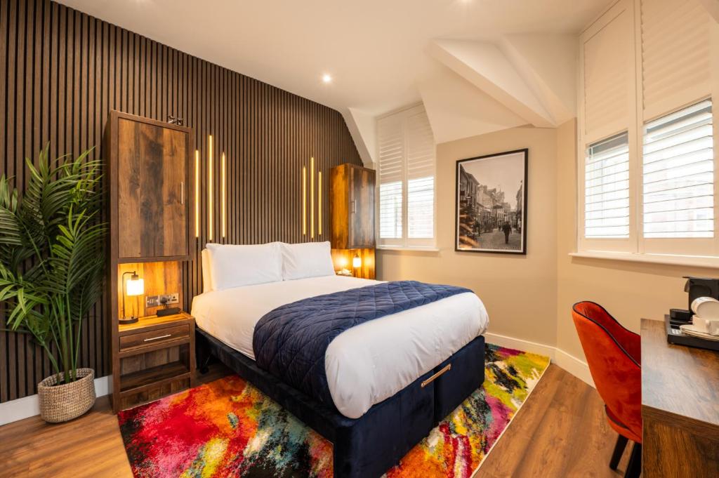 a bedroom with a large bed and a colorful rug at Parade House - A St David Aparthotel in Barrow in Furness