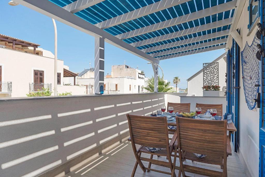 a patio with a table and chairs on a balcony at Suite Horizon Marine in San Vito lo Capo