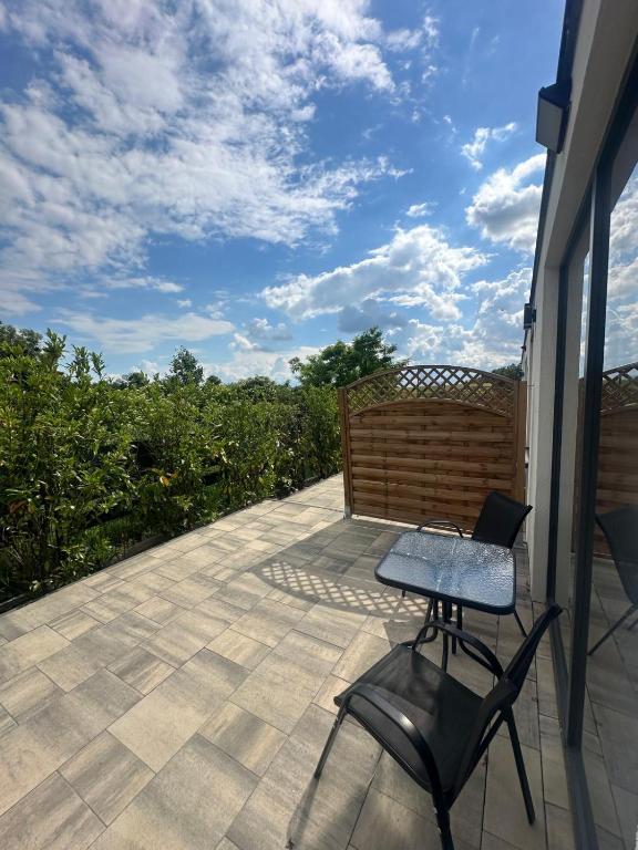 a patio with a table and two chairs on it at Olmar Przybrodzin in Przybrodzin