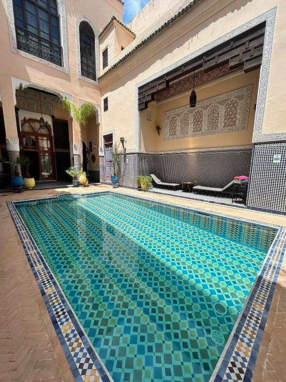 a swimming pool in front of a house at Riad Fes Baraka Piscine & SPA in Fez