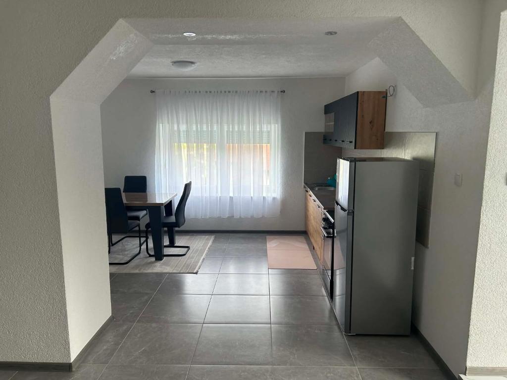 a kitchen with a refrigerator and a table with chairs at Apart centar Pliva , Jajce in Jajce