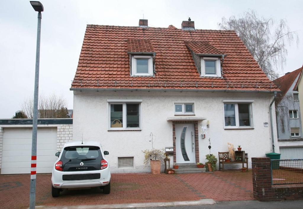 a car parked in front of a white house at Ferienwohnung Möbus in Fritzlar