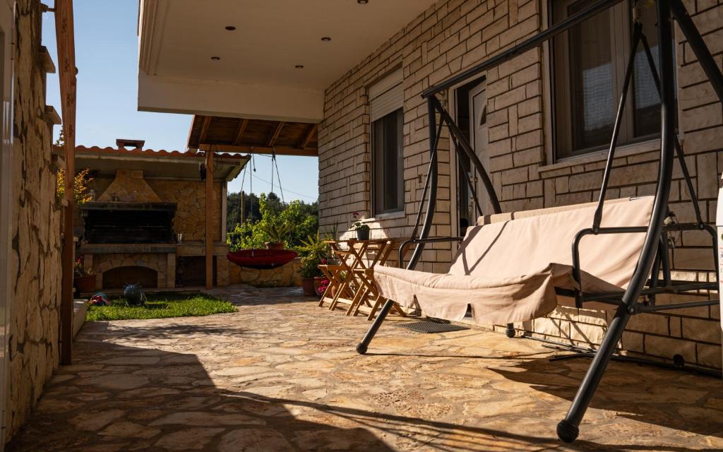 a rocking chair on a patio with a fireplace at Nice & Cosy apartment in Igoumenitsa in Igoumenitsa