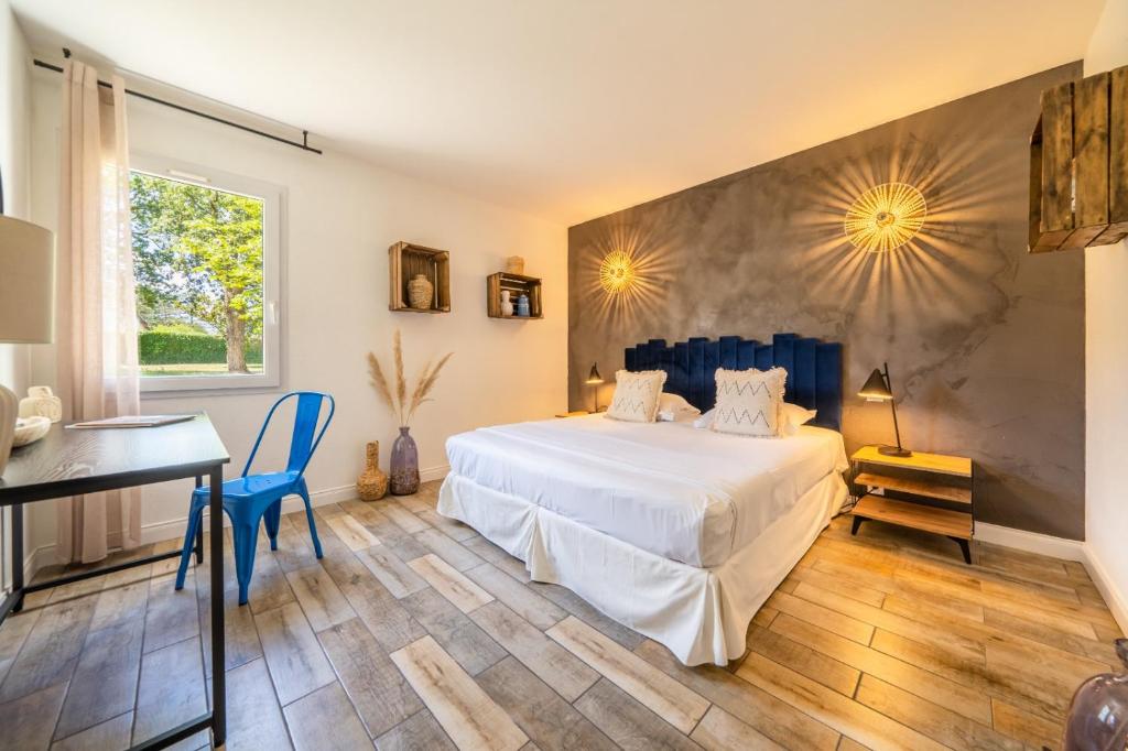 a bedroom with a large white bed and a desk at Hôtel de la Brière et Restaurant Les Krapados in Saint-Lyphard