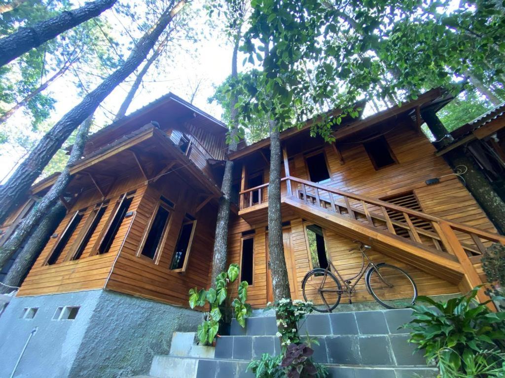 a wooden house with a bike parked in front of it at Cozzy Mutiara Rahong in Pengalongan