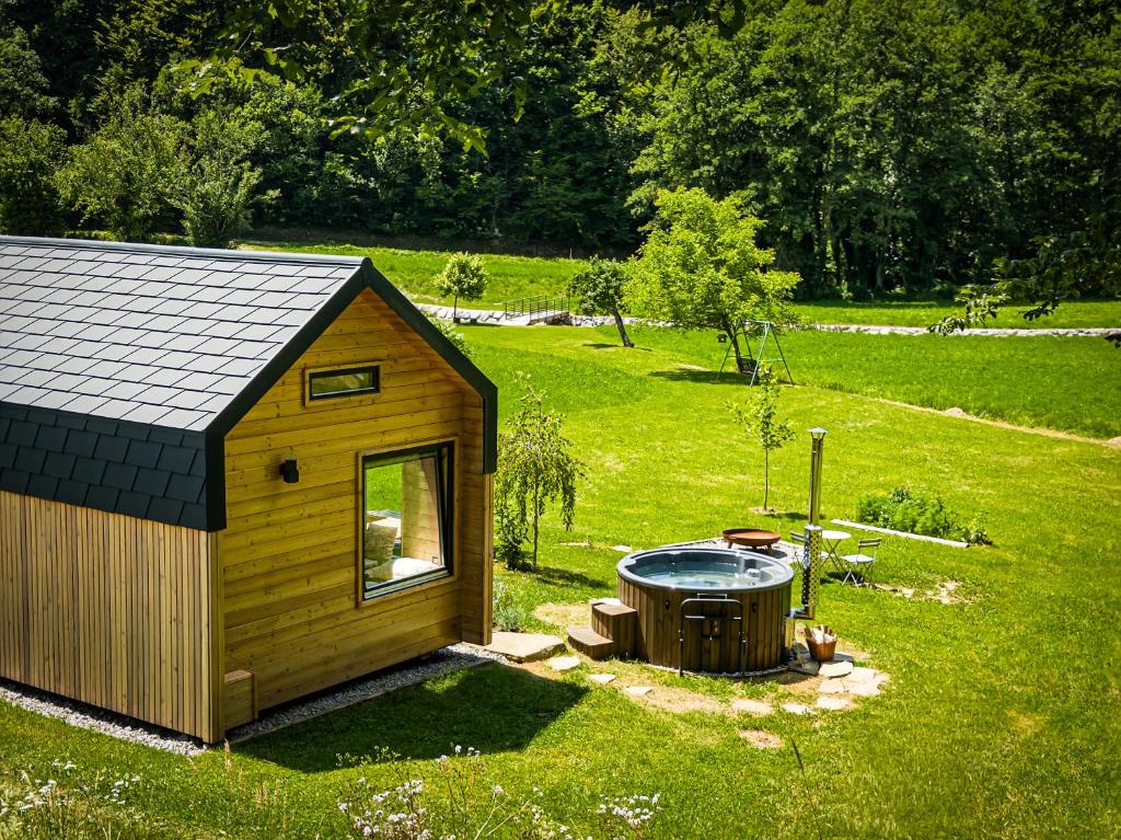a small shed with a hot tub in the grass at Posestvo Brida in Ilirska Bistrica