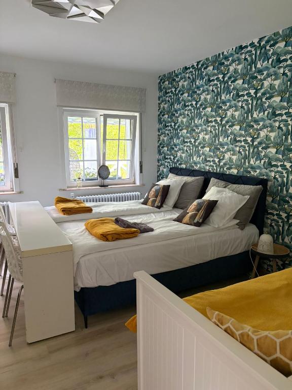 two beds in a room with green wallpaper at Les studios du Domaine d'Eva in Libramont