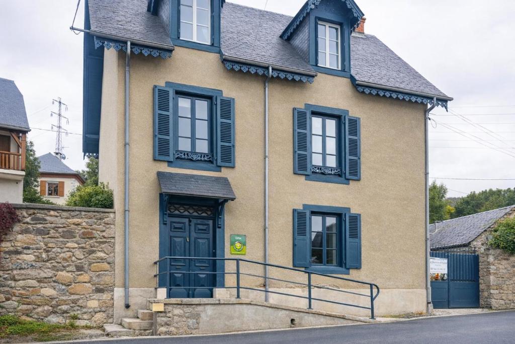 a house with blue shutters on a street at La Maison d'Aure in Arreau