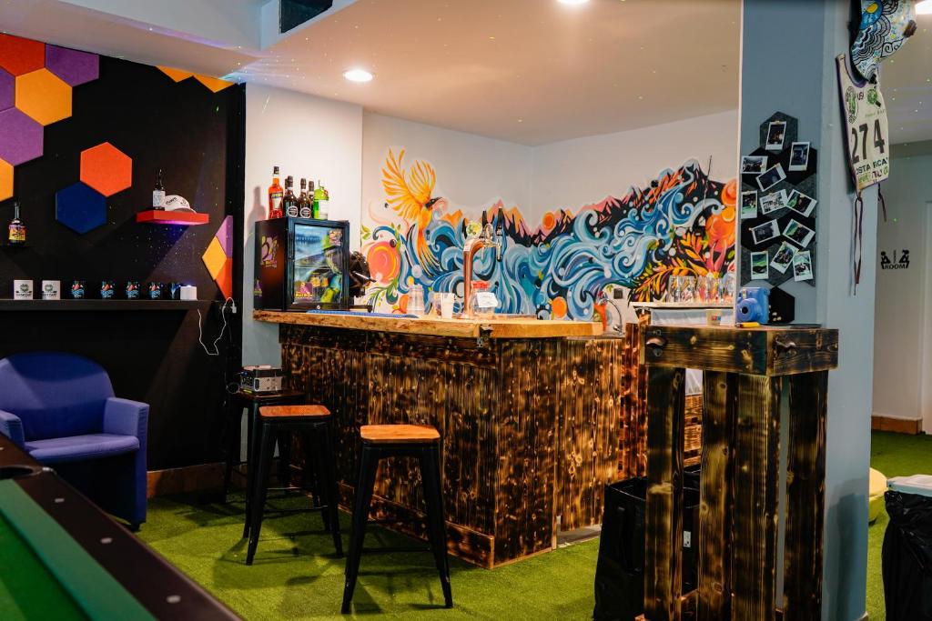 a bar with stools and a colorful wall at Valsesia Hostel in Scopello
