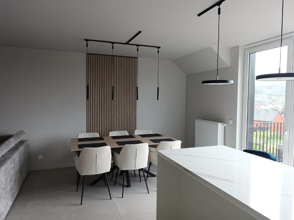 a dining room with a table and chairs and a window at Chez nous a Durbuy in Durbuy