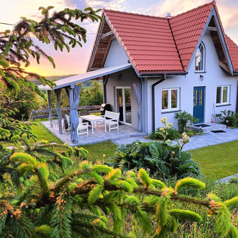 a white house with a red roof at Domek letniskowy in Kolno