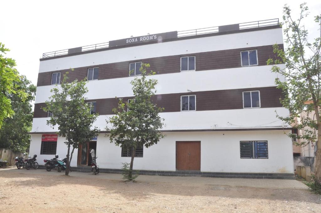 an apartment building with white and brown at Sona Rooms in Tiruchirappalli
