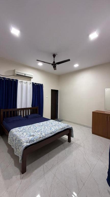 a bedroom with a bed with blue sheets and a ceiling at Hotel calm resort in Murud
