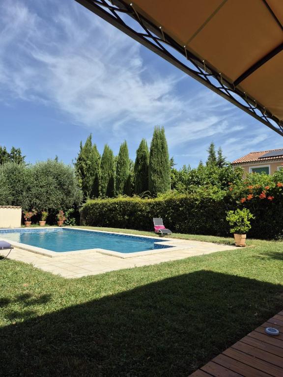 a swimming pool in the yard of a house at La Maison Verte in Tulette