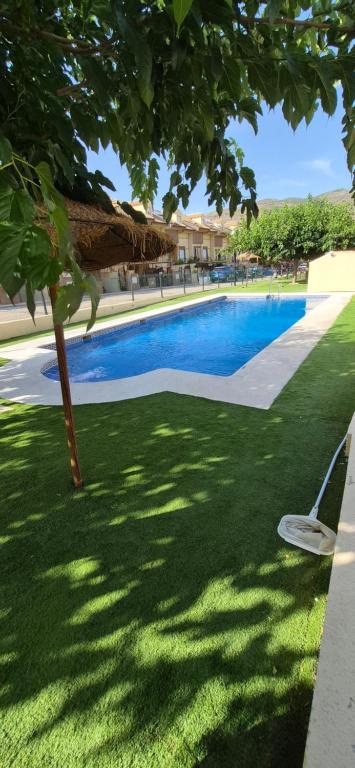 a swimming pool with a chair in the grass at Villa Rural Las Lomas in Jaén