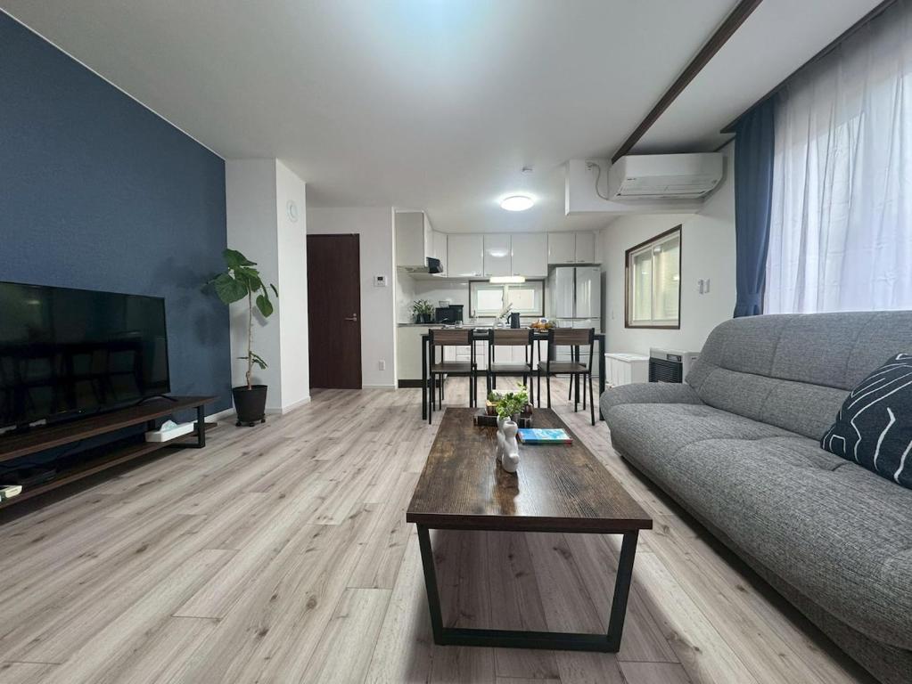a living room with a couch and a coffee table at Guest house LIA1 in Abashiri