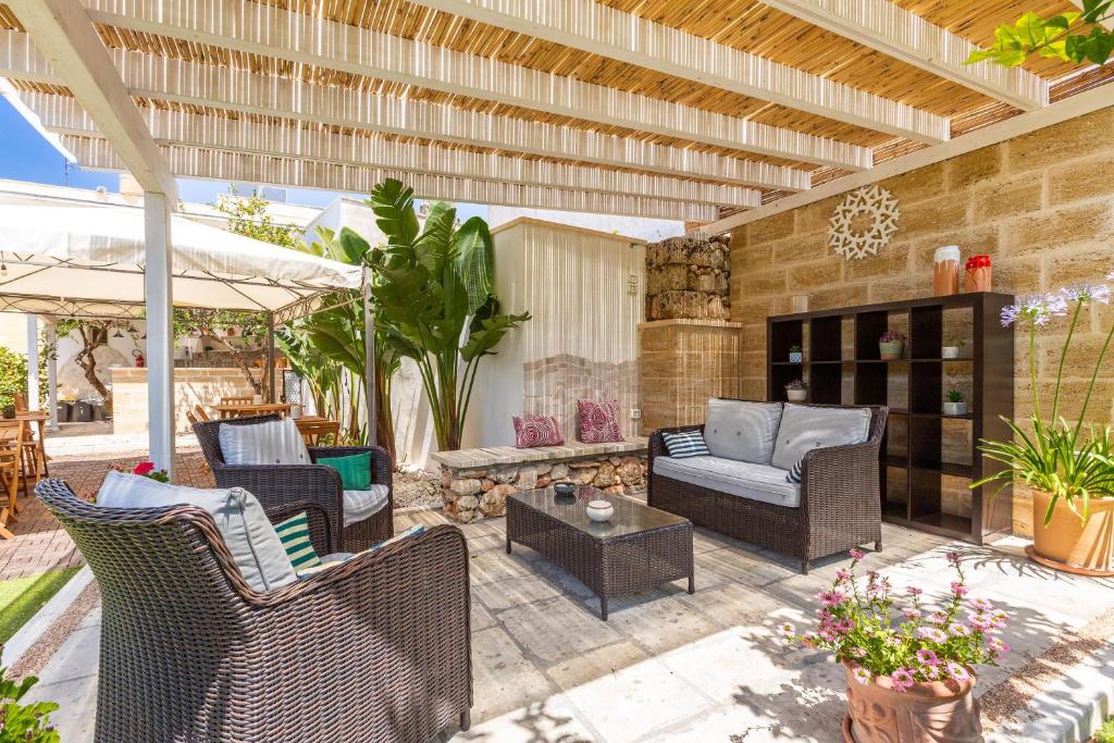 an outdoor patio with chairs and a fireplace at Dimora Ferente in Salve