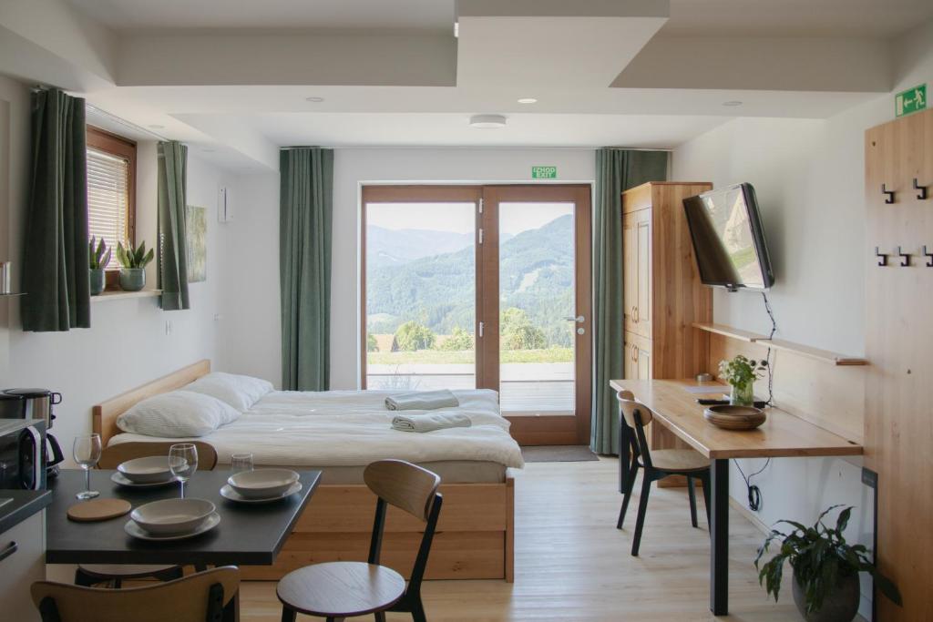 a living room with a bed and a table with chairs at Nad vasjo in Železniki
