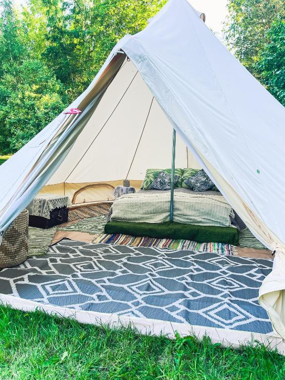 a white tent with a mattress in the grass at Lahemaa Nature Glamping - Koit in Vihasoo