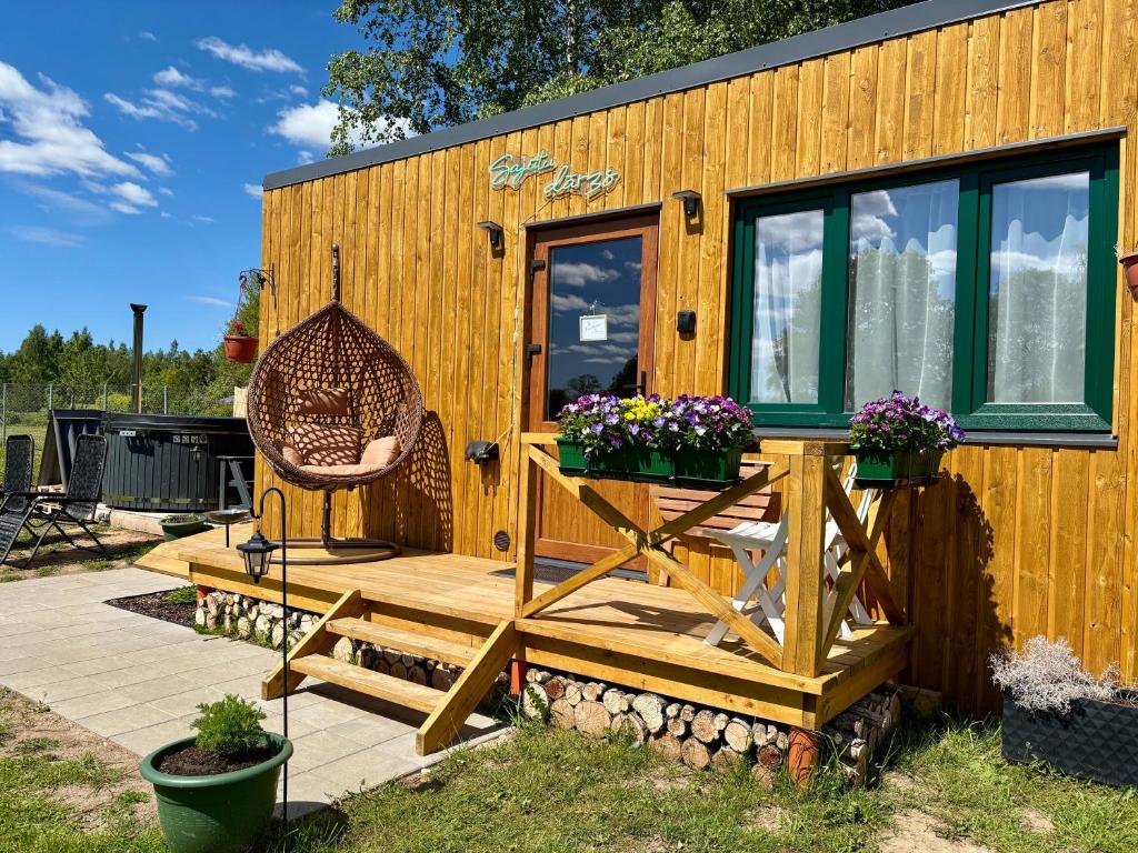 a tiny house with a bench and a chair at Sajūtu dārza mājiņa in Augšlīgatne