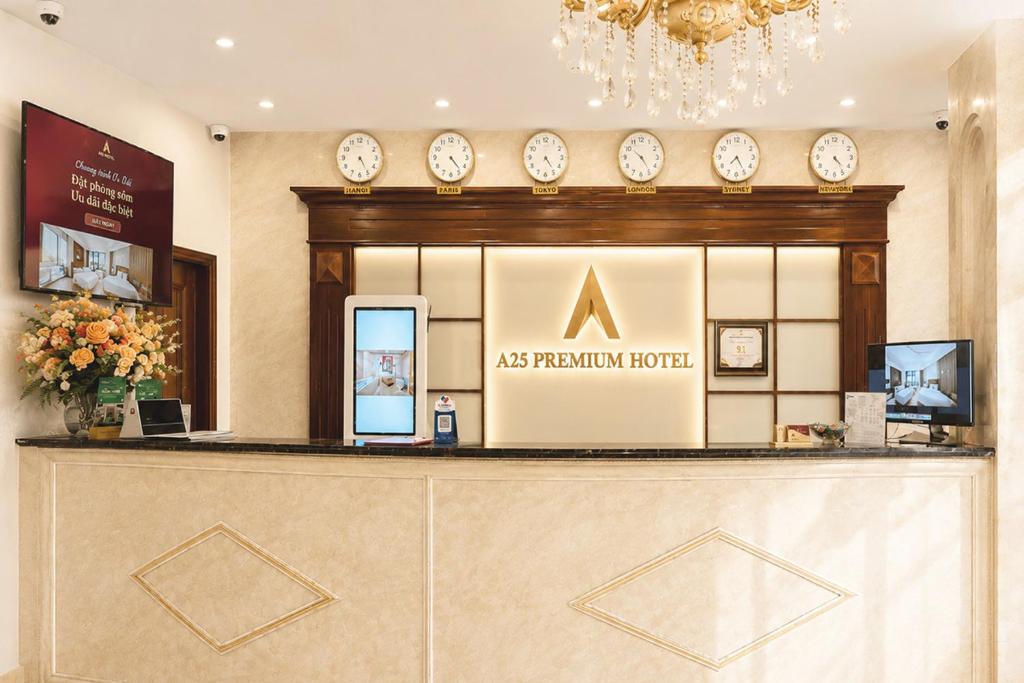 a reception counter with clocks on the wall at A25 Premium Hotel - 23 Quán Thánh in Hanoi