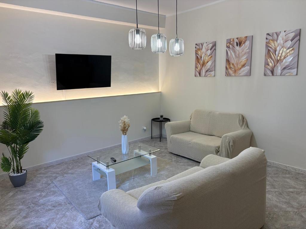 a living room with two couches and a tv at Chill House Reggio Calabria in Reggio di Calabria