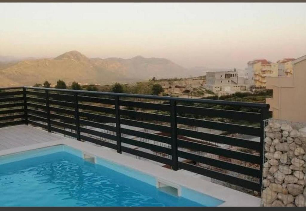 a swimming pool on a balcony with a view of the mountains at Apartman Anela in Ivanica