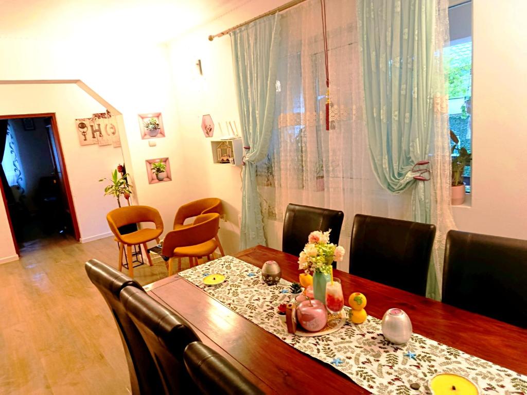 a dining room with a wooden table and chairs at Casa Naomi in Eforie Nord