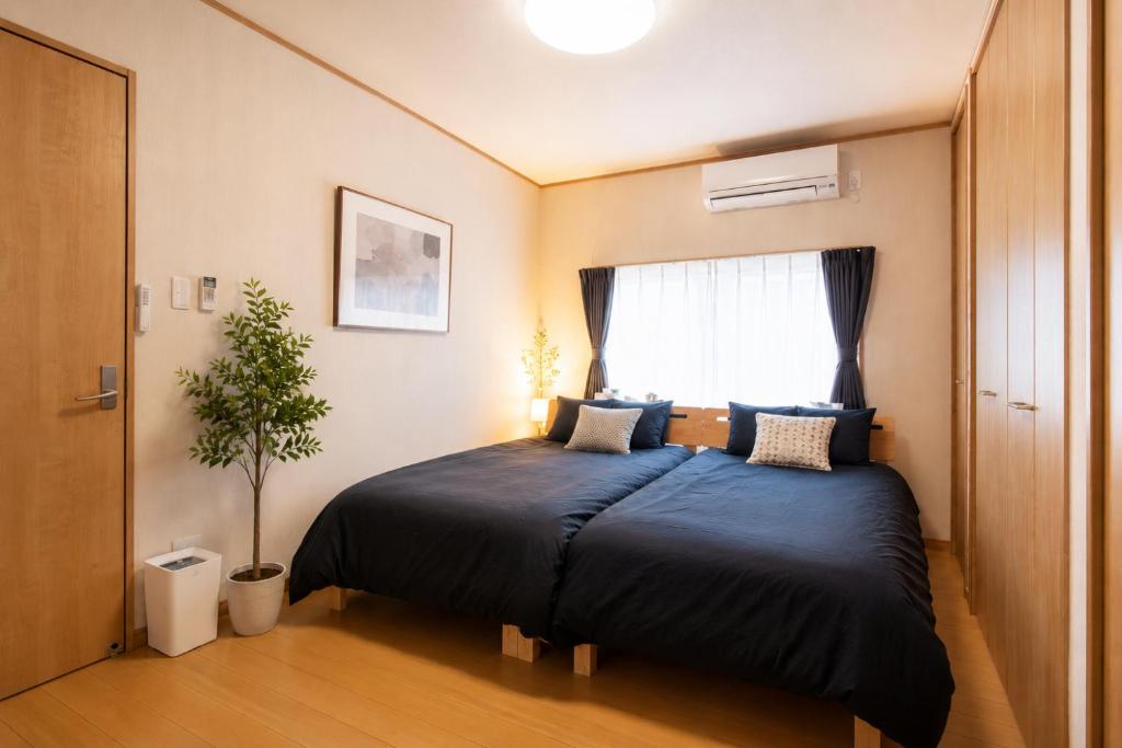 a bedroom with a large bed with a window at バンビホーム青森中央 in Aomori