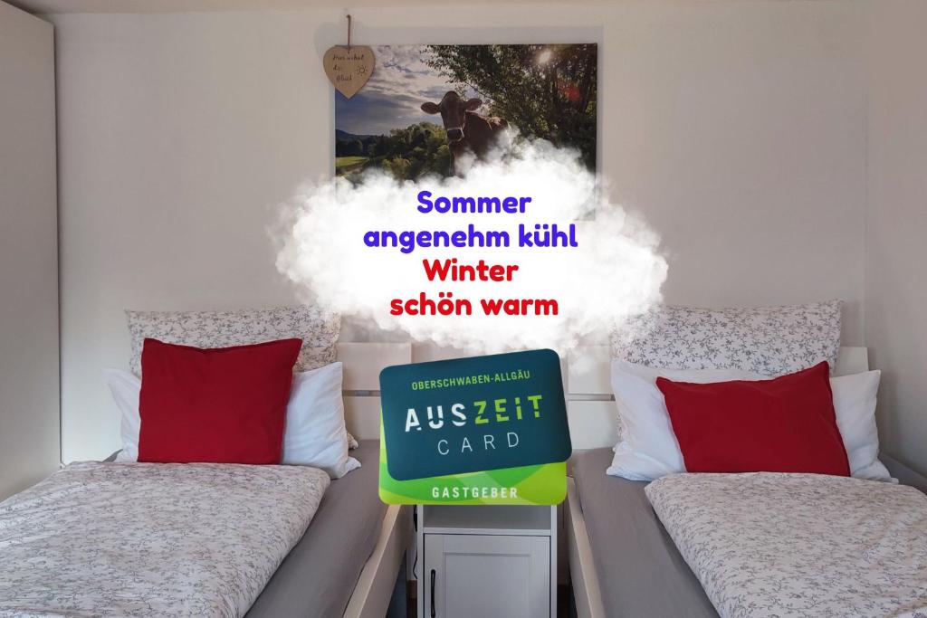 a bedroom with two beds and a sign on the wall at Ferienwohnung Trifts l Wallbox l Parkplatz l AusZeit Card in Wangen im Allgäu