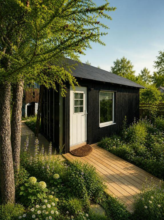 a small black shed with a wooden deck at Tiny House - The LOWFO House Lofoten in Moskenes