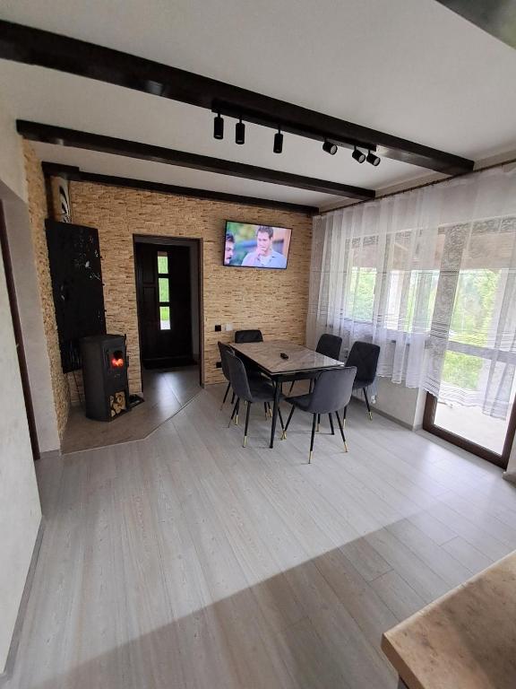 a dining room with a table and chairs and a tv at Вершина Мрій in Slavske
