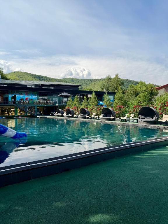 a large swimming pool in front of a building at Mirali Resort in Almaty
