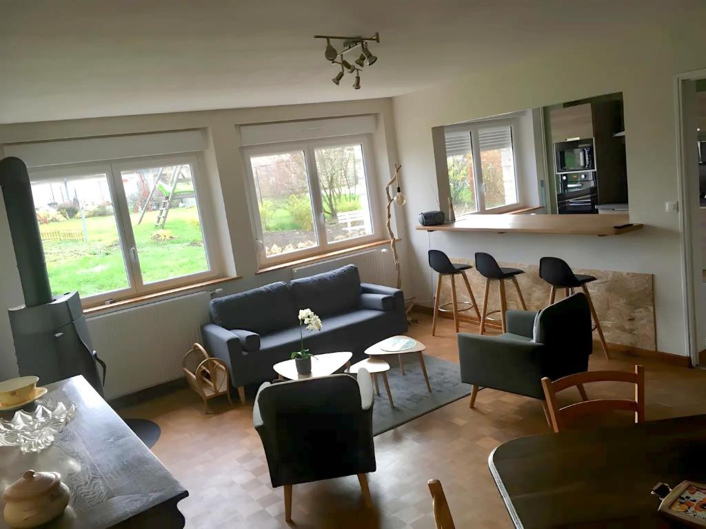 a living room with a couch and a table and chairs at Gîte Saint Gorgon in Euville