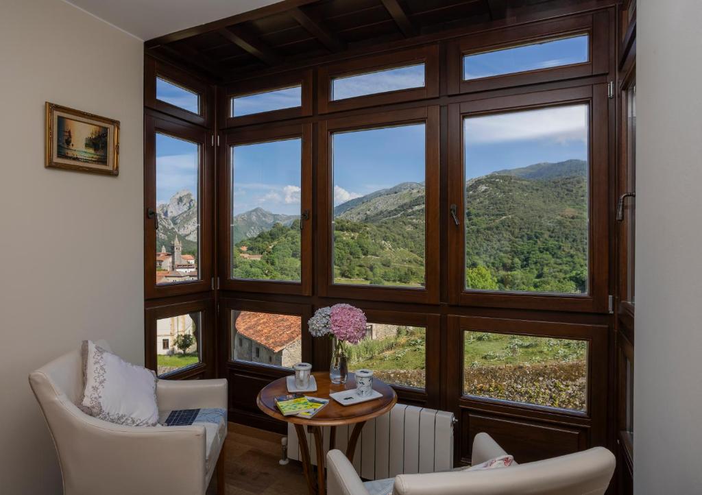 a room with large windows and a table and chairs at La Posada del Vencejo in Alles