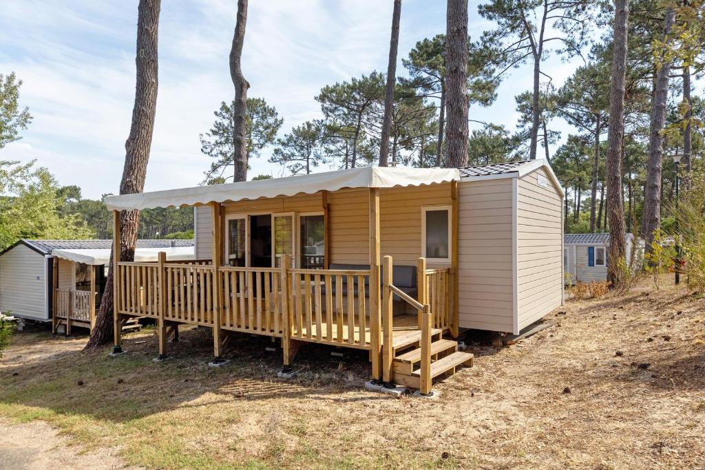 a tiny house in the woods with a porch at Bungalow Cap Ferret Les Lodges 2 in Lège-Cap-Ferret