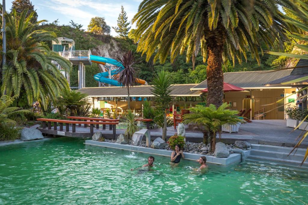 3 personnes dans une piscine d'un complexe dans l'établissement Taupo Debretts Spa Resort, à Taupo