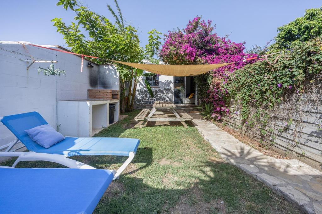 a yard with a blue chair and a fence at Sunwaves 2 - Casa Oasis in El Palmar