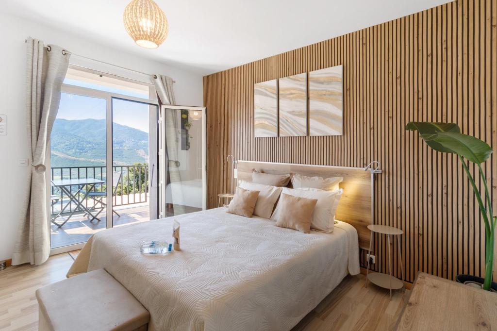 a bedroom with a large bed and a balcony at Douce Heure & Saveurs in Tavaco