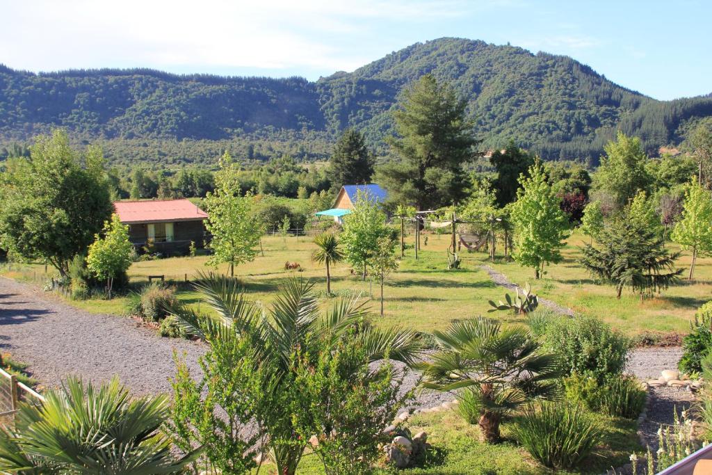 a view of a garden with trees and a house at La Maravilla Lodge in Vilches