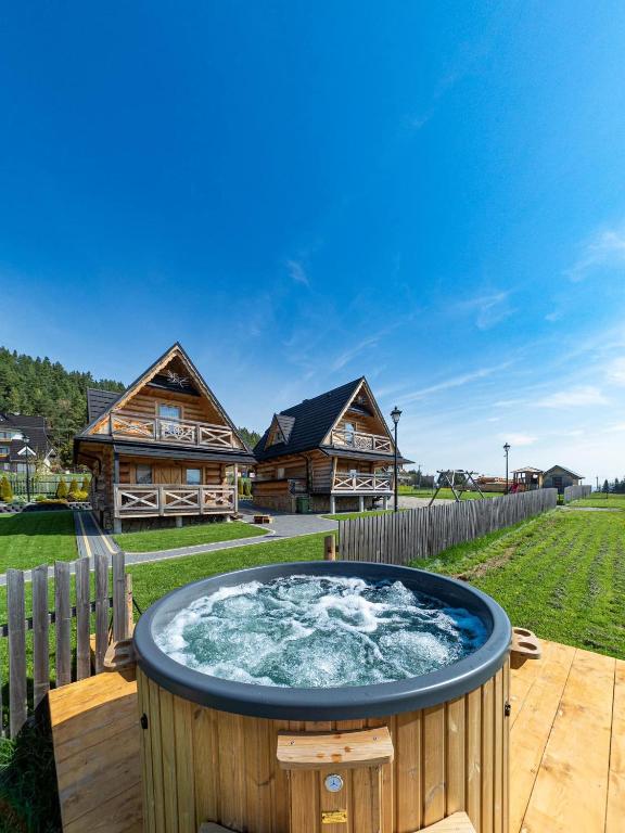 a hot tub in the yard of a log cabin at Osada Szaflary - jacuzzi na wyłączność dla każdego domku, ogólnodostępna sauna i plac zabaw w cenie in Szaflary