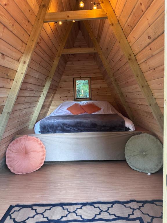 a bedroom with a bed in a wooden attic at Little Brook Glamping in Salfords
