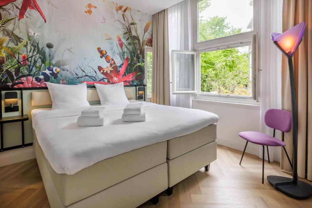 a bedroom with a large bed and a colorful wall at Dutch Design Hotel Vondelpark in Amsterdam