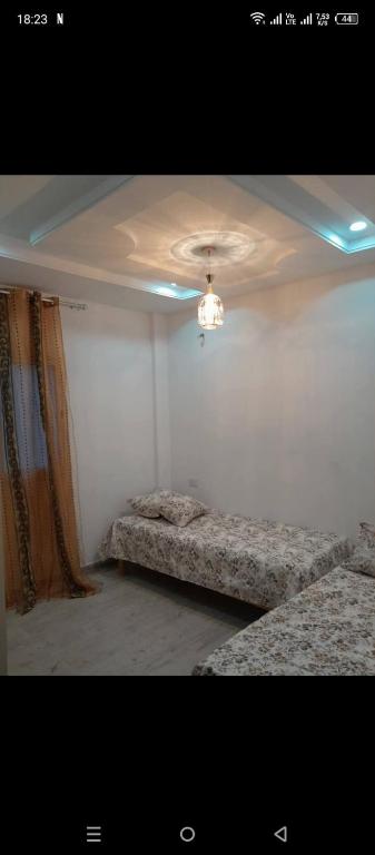 a room with two beds and a chandelier at Jouini tasyif in Kelibia