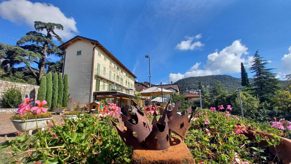 a garden with flowers in front of a building at Residence delle Tre Corone in Trescore Balneario