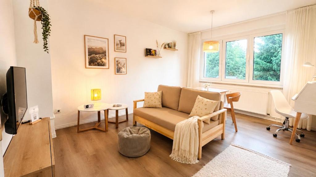 a living room with a couch and a table at happyhome mitten im HARZ - direkte Wanderwege - Bachplätschern - Küche - Kinderfreundlich - Paare und Freunde in Elend