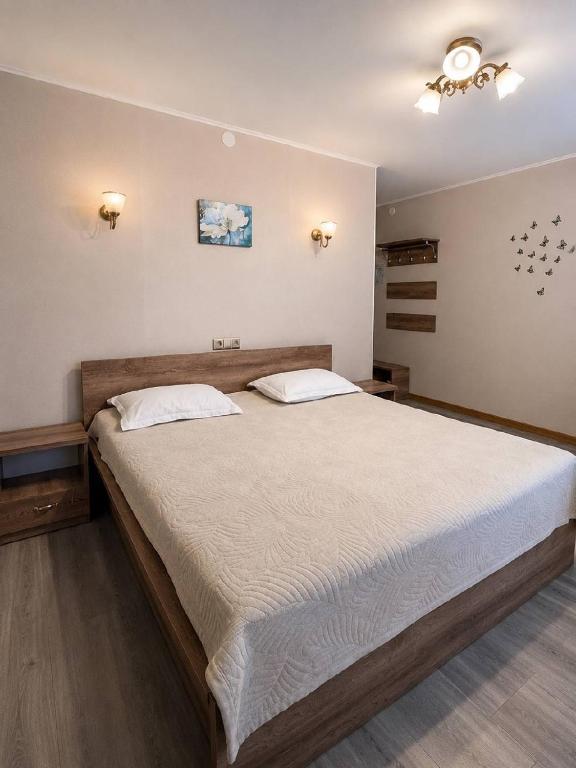 a bedroom with a large bed with white sheets at Baiterek Resort in Karagandy