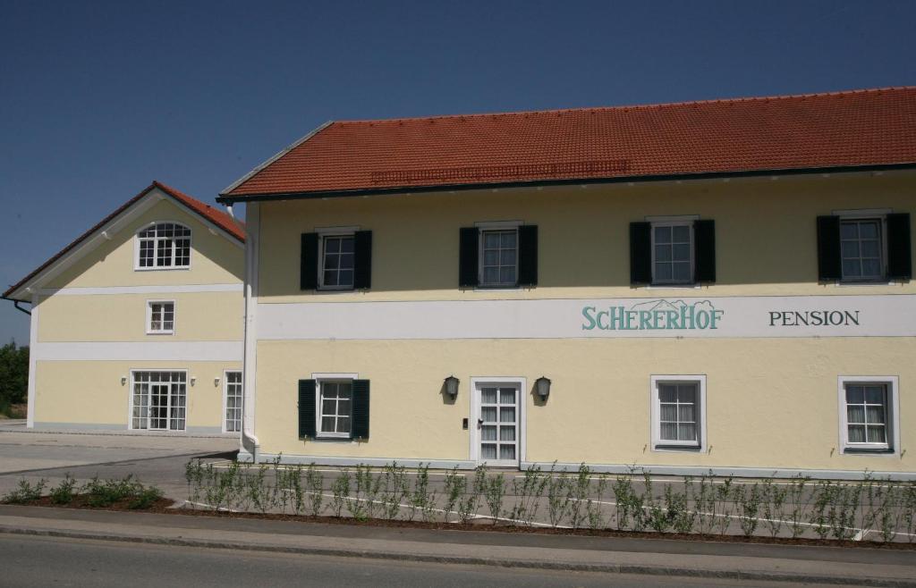 a yellow and white building with a red roof at Pension Schererhof in Pliening