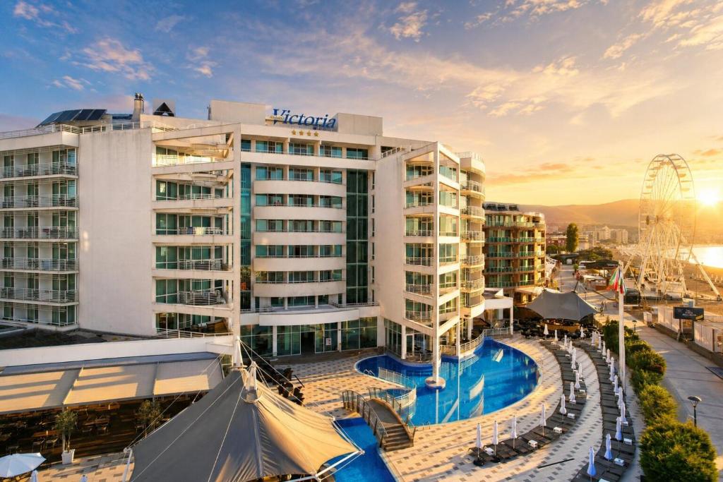 a hotel with a pool and a ferris wheel at Effect Grand Victoria Hotel - Ultra All Inclusive in Sunny Beach